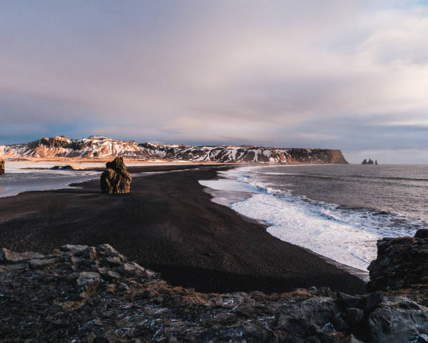 istock Arnardrangur sea stack and Reynisdrangar basalt columns on the black sand beach, South Iceland. 2195694473