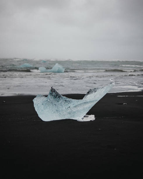 Striking blue ice shard on black sand at Diamond Beach, South Iceland