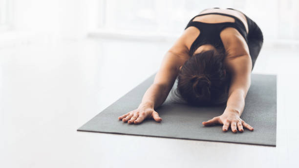 istock Woman Practicing Yoga in a Studio With Natural Light During Early Morning Hours 2195695372