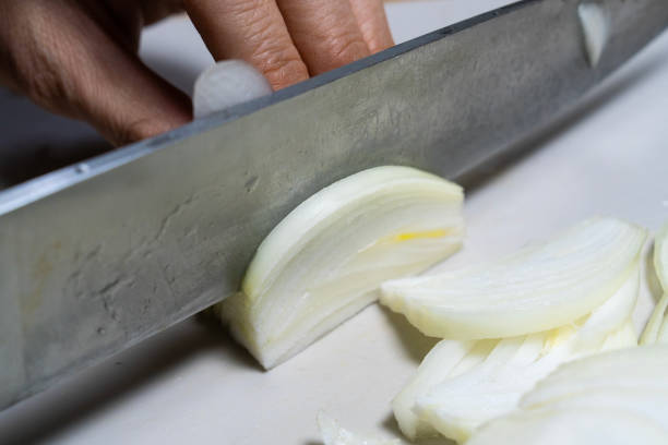 istock cutting onion with a knife on the cutting board 2195696460