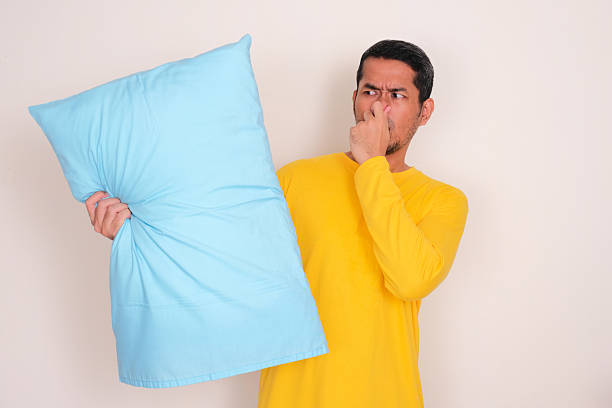 istock A man cover his nose when holding smelly pillow 2195698032