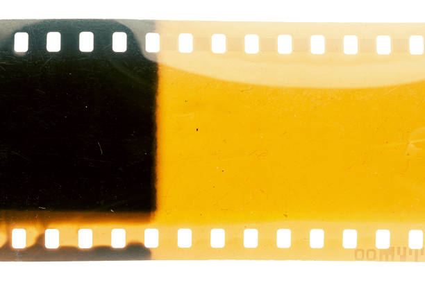 Dusty and grungy 35mm film texture or surface. Perforated scratched camera film isolated on white background.