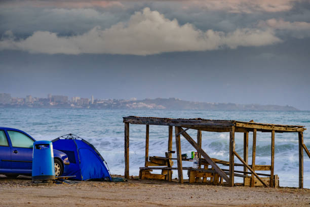 istock Car and tent on beach. Camping on seashore 2195702681