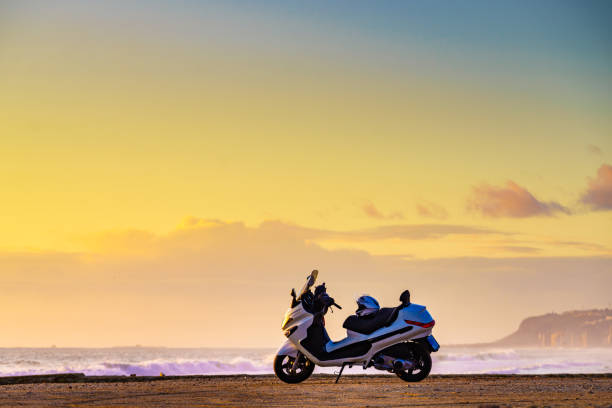 Scooter motorbike on beach sea shore at sunrise. Touring in nature.