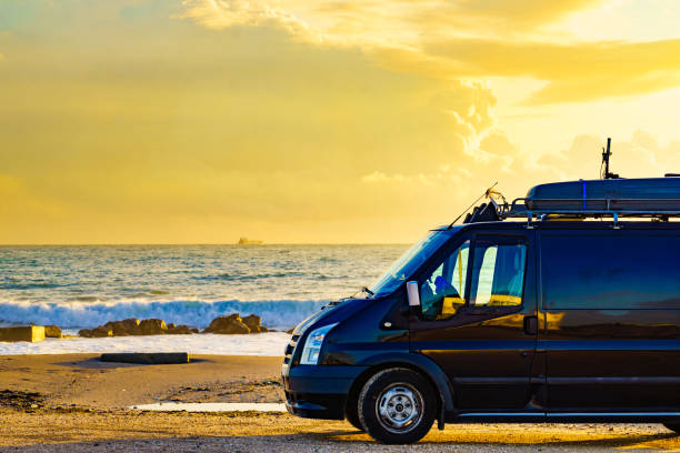 istock Camper van on beach at sunrise 2195705800