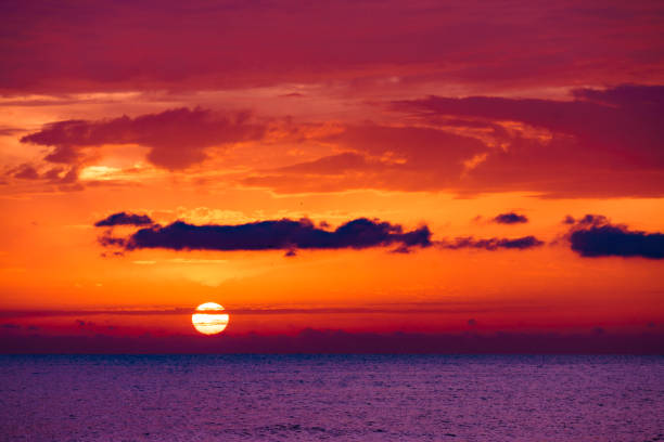 Sunrise over sea. Burning sky with over water surface. Sun rising above horizon. Morning seascape.