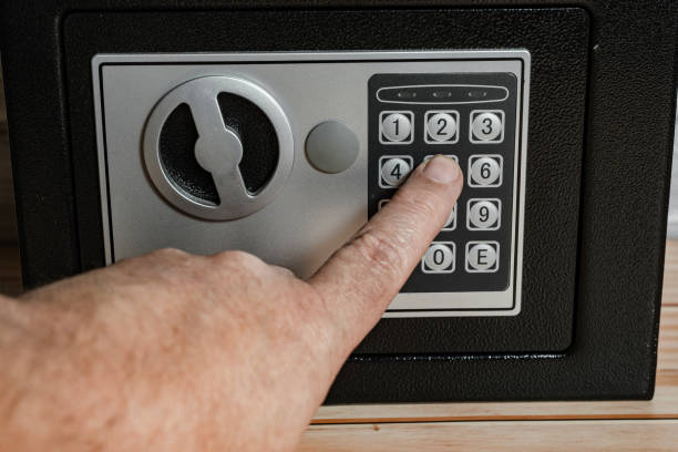 istock Man entering the opening code on the numeric keypad of the safe. 2195707915
