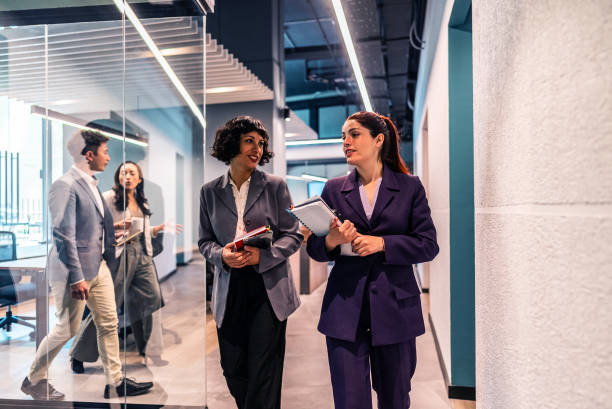 istock Coworkers talking and walking on office corridor 2195708584