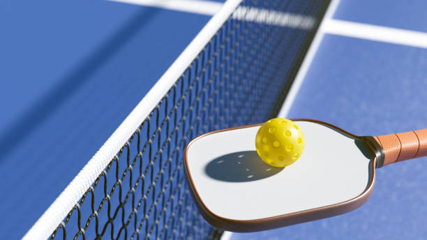 istock A yellow ball on a pickleball racket near the net. 3d rendering 2195714232