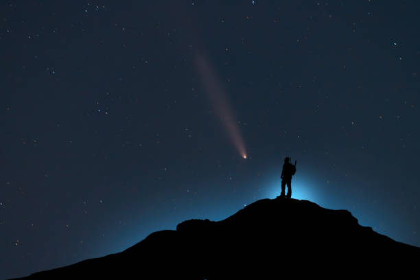 istock Silhouette of a hiker standing on the hill,  starry sky with bright comet. 2195716697
