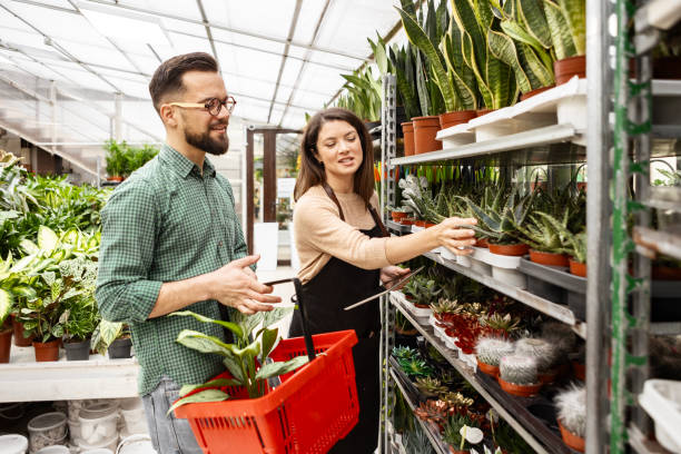 istock Customer Browsing Potted Plants with Florist’s Digital Guidance 2195718421