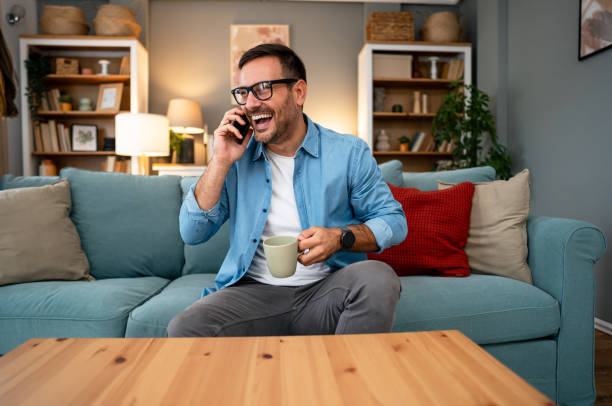 istock Young cheerful man talking on the phone at home 2195720211