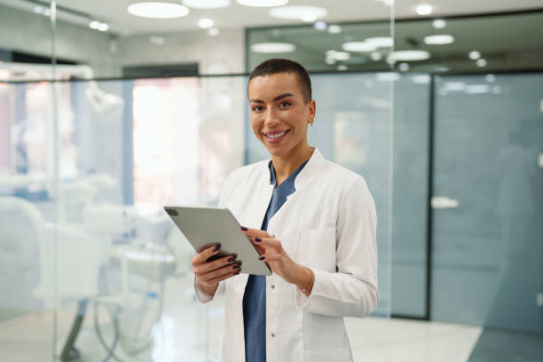 istock Cheerful Female Dentist with Digital Tablet in Office 2195721613