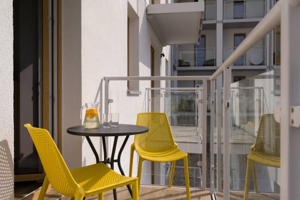 istock Sunny Balcony with Yellow Chairs and Refreshing Drink 2195721703