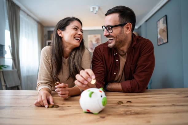 Couple inserting coins in a piggybank