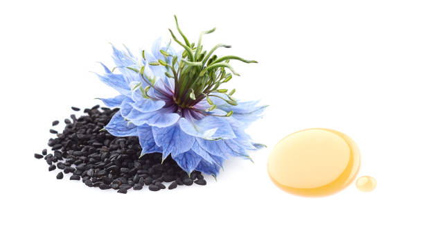 Black cumin seeds with flower and drop oil on white background