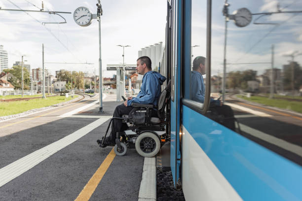 istock Man with a physical disability, an electric wheelchair user entering a train 2195725132