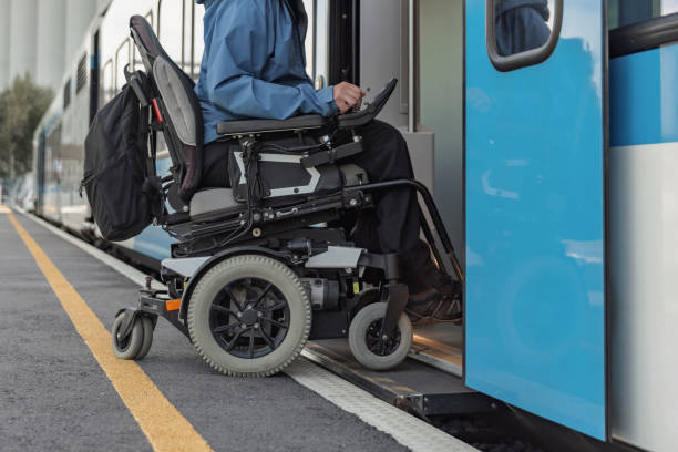 istock Man with a physical disability, an electric wheelchair user entering a train 2195725144