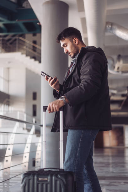 istock Businessman using smartphone while waiting at the airport 2195743689