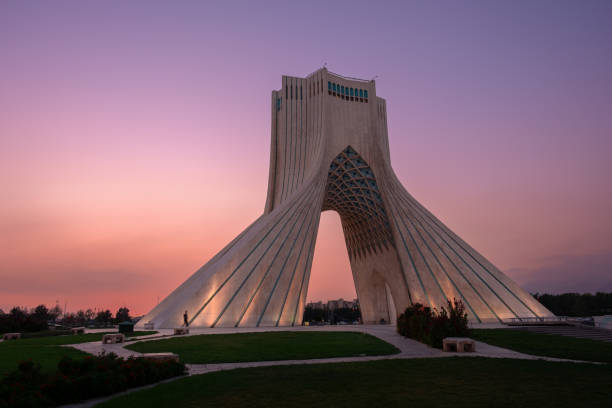 The azadi tower in tehran, iran, is bathed in the warm glow of the setting sun, creating a picturesque scene that captures the beauty and history of this iconic landmark