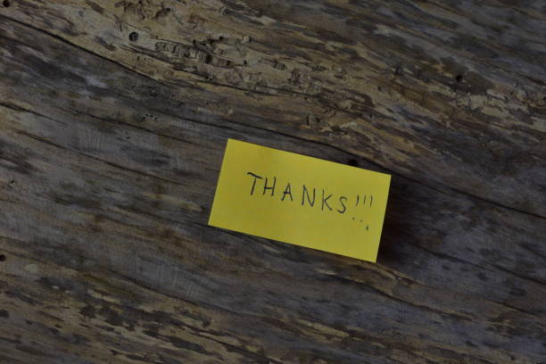 Message thanks thank you on yellow sticky note day on wooden board textured background