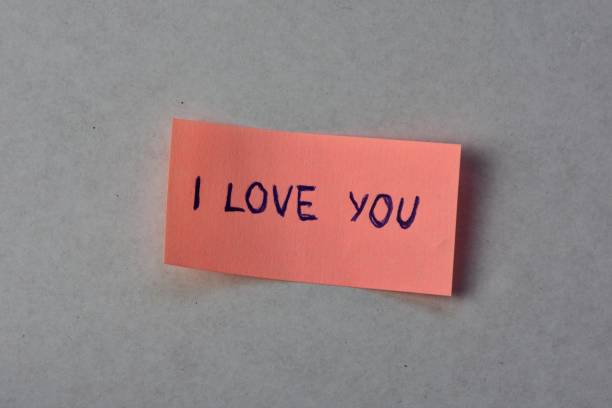 istock Message I love you on pink sticky note for valentines day on white cardboard background 2195748683