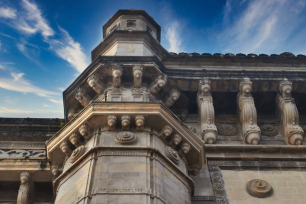 Elaborate stonework defines a grand archway that captures sunlight, showcasing detailed carvings and historical significance of Gateway of India