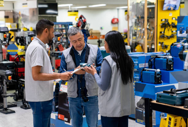 istock Business manager training two new workers at a hardware store 2195758838