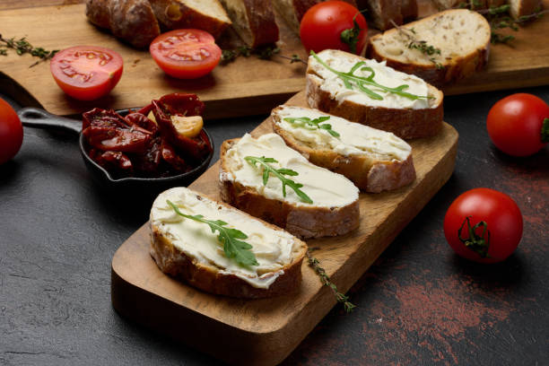 istock Cream cheese spread on ciabatta pieces and decorated with arugula leaves, appetizer 2195766071