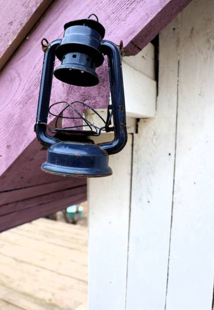 A classic black lantern hangs on a rustic porch, creating a warm ambiance for the cabin