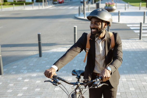 istock Man walking his bicycle in an urban area while wearing a business suit 2195773321