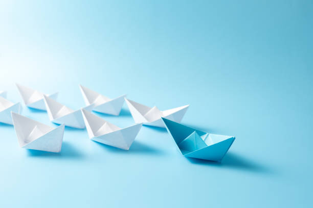 istock Leadership concept with blue paper ship leading among white 2195776277