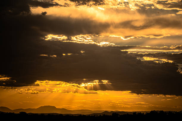 istock Scenic view of dramatic sky at sunset with rays beaming through the clouds over the mountain range, New South Wales, Australia 2195778555