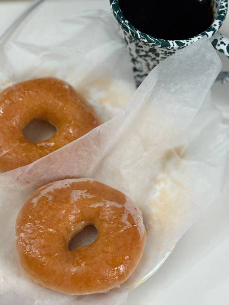 istock A classic glazed donut with a soft, fluffy texture and a sweet, glossy coating. Perfectly balanced between light and sugary, making it an irresistible treat for any time of the day. 2195779108