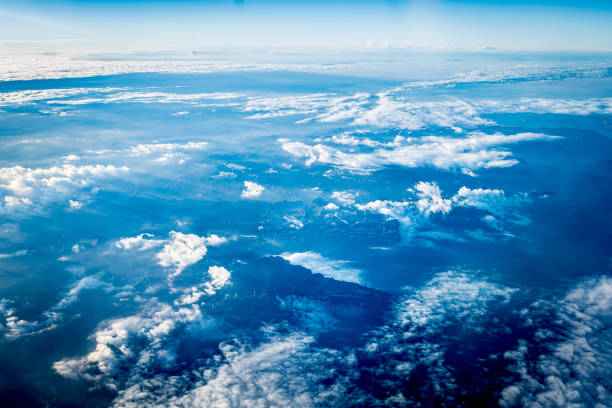 Looking out the airplane window, admiring the blue sky and clouds