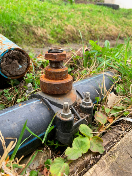 istock Rusty pipe is sitting on the ground next to a grassy area 2195781866