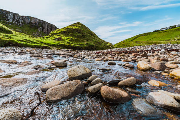 Scenic view of a river flowing through rocks in a green valley in the isle of skye, scotland