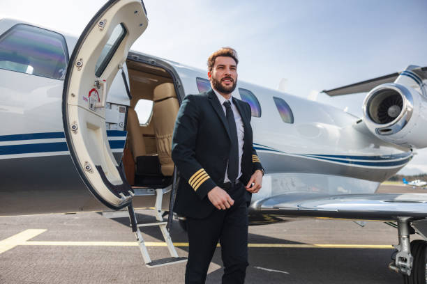 istock Confident Pilot with Private Jet at Airport 2195789410