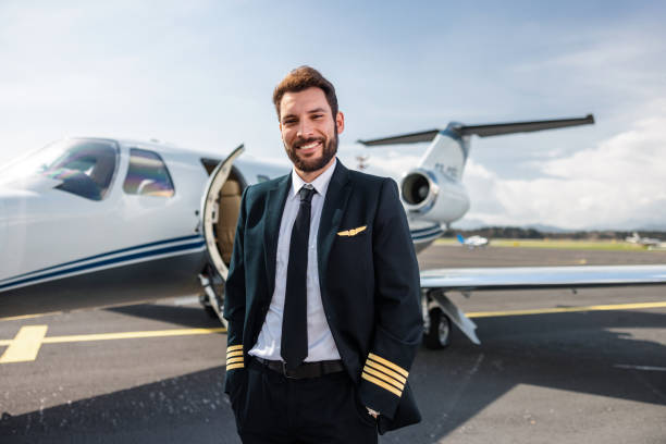 istock Confident Young Male Pilot Posing with Private Jet 2195789418