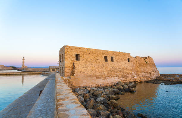 Breakwater and Lighthouse Walk past historic bastion in Chania Crete.