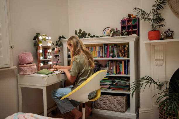 istock Young girl studies focused in her cozy room 2195803907