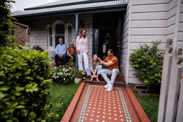 istock Happy family on front porch together 2195804051