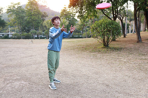 Little boy plays frisbee in park