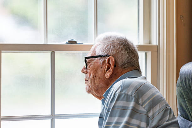 istock Elderly Man Wearing Hearing Aid Looking Through Living Room Window 2195805678