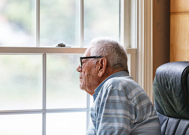 istock Elderly Man Wearing Hearing Aid Looking Intently Through Window 2195805743