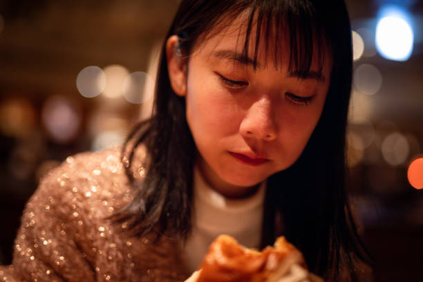 Young woman eating hamburger in cafe