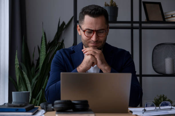 istock Pensive businessman working from home contemplates next move on laptop 2195808930