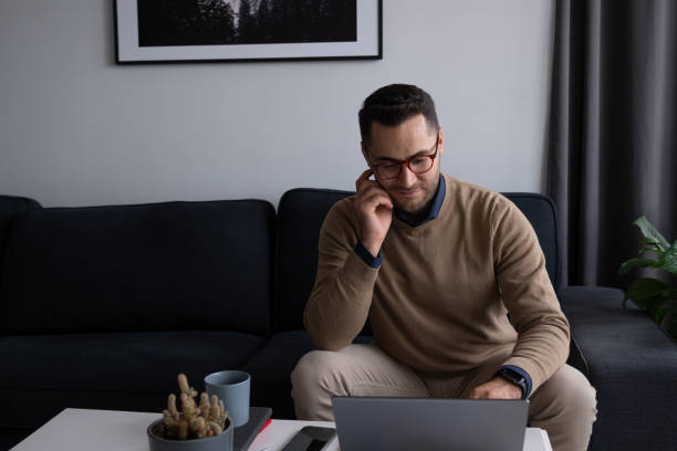 istock Focused businessman working from home sitting on the couch using laptop 2195809011