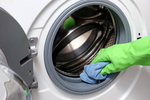 istock A woman's hand in a protective rubber glove wipes away moisture a washing machine. 2195809572