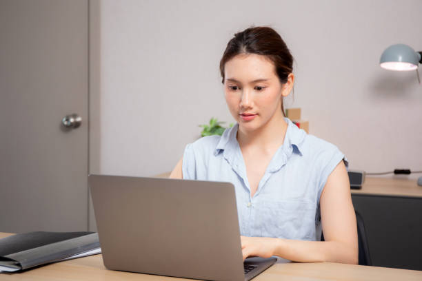 istock Young caucasian woman sitting and using laptop computer planning for success in modern office, businesswoman typing and watching notebook with confident, employee working on desk, business concept. 2195809800